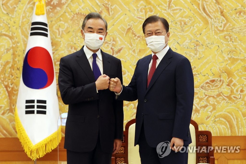 9月15日，在青瓦台，韩国总统文在寅（右）和中国国务委员兼外交部长王毅合影留念。 韩联社