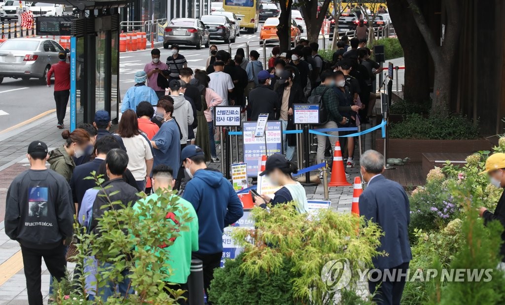 资料图片：9月30日，在首尔市松坡区卫生站的新冠筛查诊所，市民们一早就前来排队接受核酸检测。 韩联社