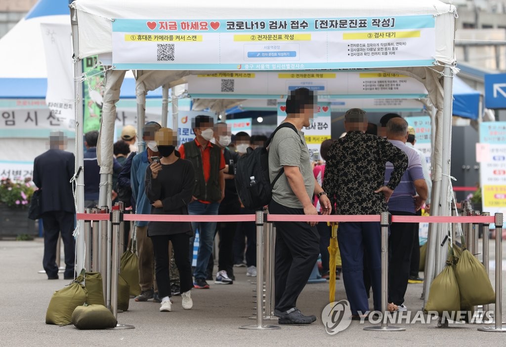 10月5日上午，在首尔站广场的核酸筛查点，市民排队候检。 韩联社