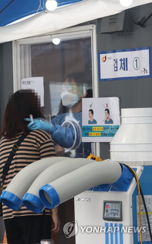 10月5日上午，在首尔站广场的核酸筛查点，市民接受检测采样。 韩联社