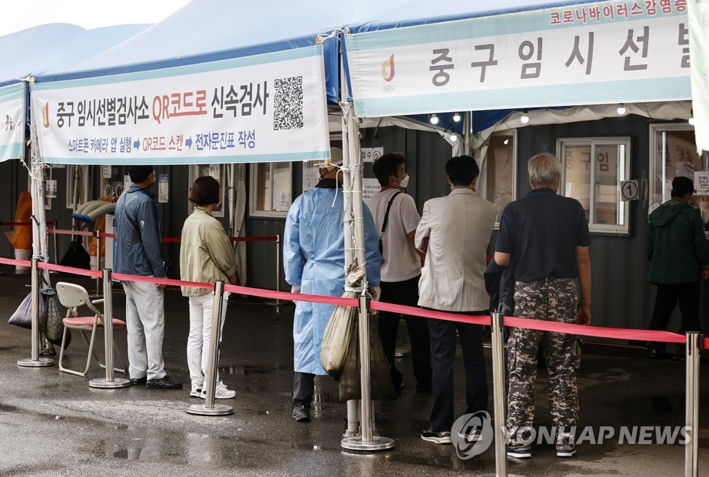资料图片：10月11日，在首尔站广场临时筛查诊所，市民们排队等待病毒检测。 韩联社