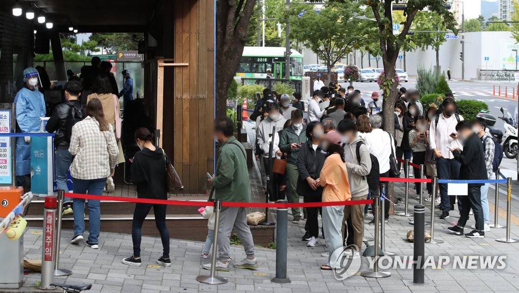 10月12日，在首尔松坡区卫生站筛查诊所，市民们排队候检。 韩联社