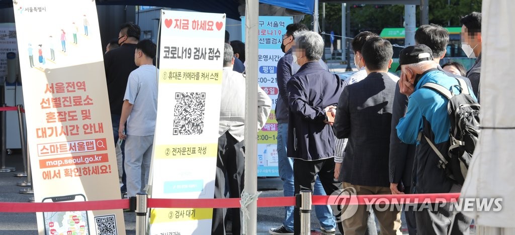 10月13日，在首尔站临时筛查诊所，市民们排队候检。 韩联社