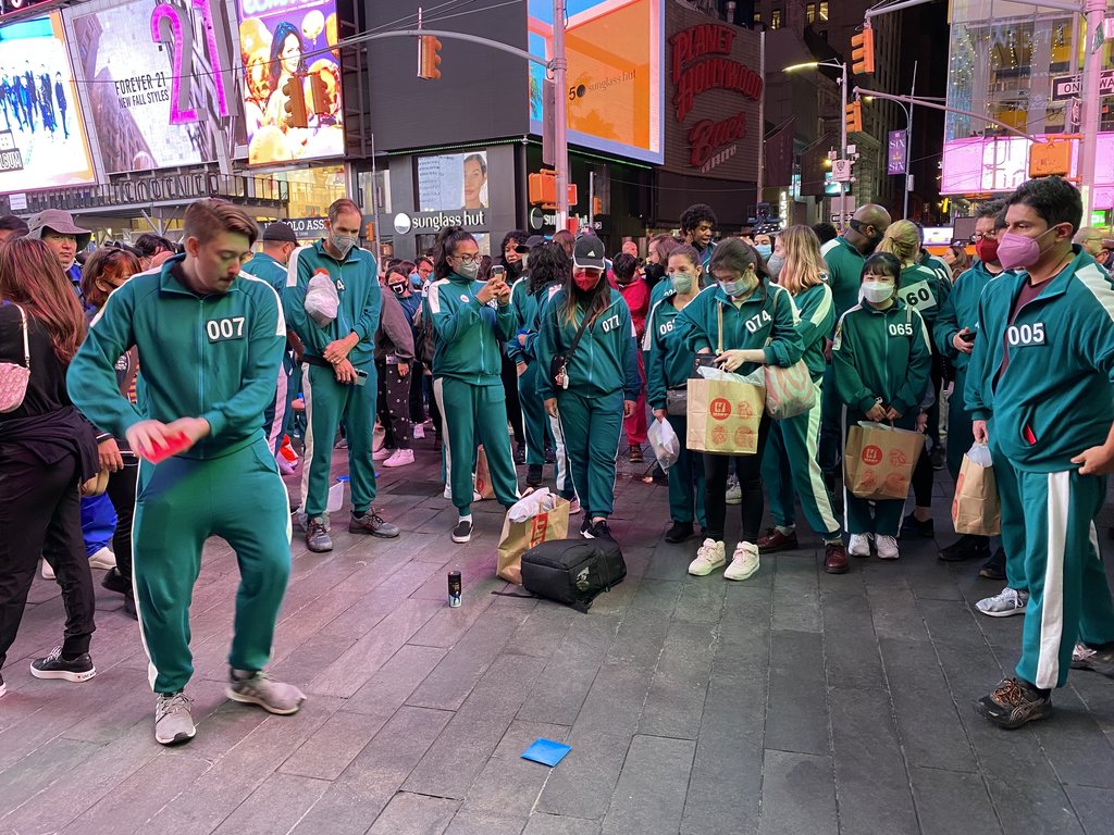 当地时间10月26日，在纽约时代广场，纽约市民在玩韩剧《鱿鱼游戏》中出现的游戏——拍画片。韩国观光公社纽约分社当天在时代广场主办以《鱿鱼游戏》为主题的韩国游宣传活动。 韩联社