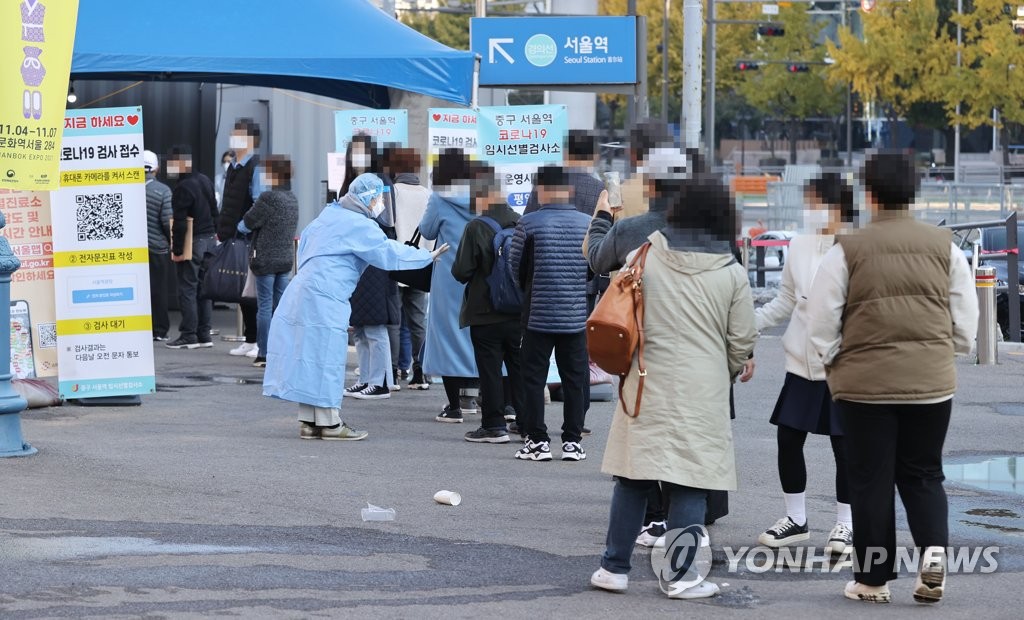 10月28日，在首尔站新冠筛查诊所，市民们排队候检。 韩联社