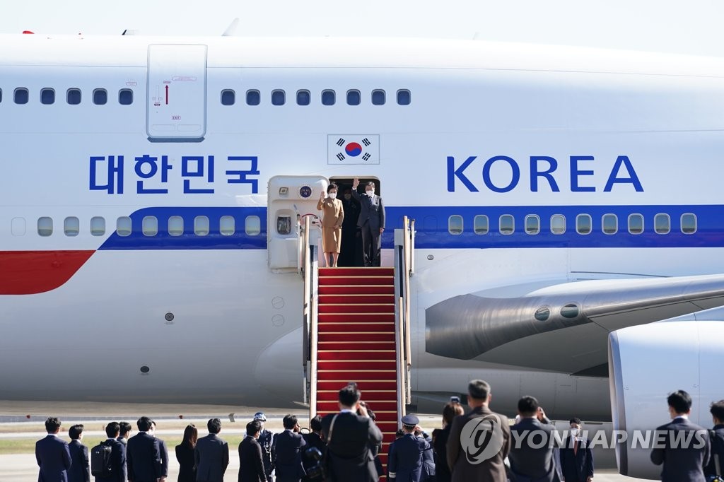 资料图片：10月28日，在京畿道城南市的首尔机场，文在寅总统和夫人金正淑登上“空军一号”专机后转身挥别欢送人群招手。 韩联社