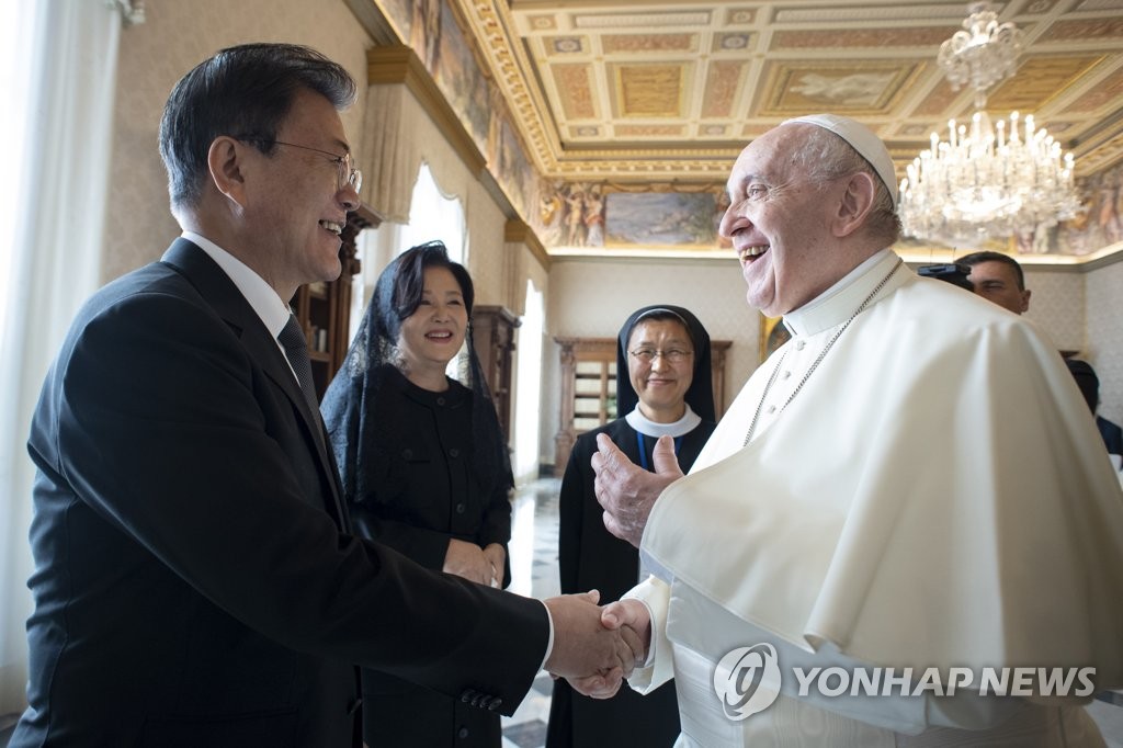 当地时间10月29日，在罗马教廷，韩国总统文在寅（左）同教皇方济各在会晤前亲切握手。 韩联社/罗马教廷供图（图片严禁转载复制）