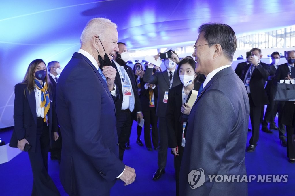 当地时间10月30日，在意大利罗马会议中心，韩国总统文在寅（右）与美国总统拜登谈笑风生。两位领导人当天在二十国集团（G20）峰会与会者合影前短暂会面。 韩联社