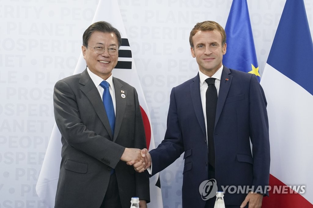 当地时间10月30日，在意大利罗马，韩国总统文在寅（左）与法国总统马克龙举行首脑会谈。图为双方合影留念。 韩联社