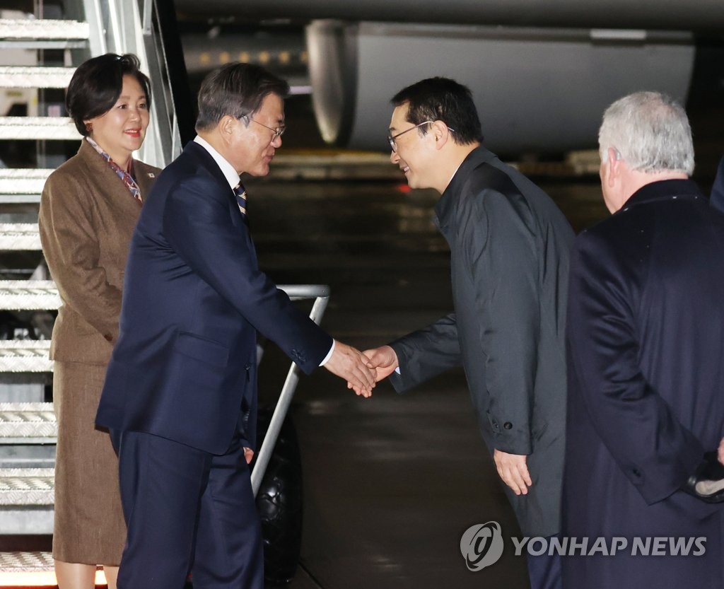 当地时间10月31日下午，在英国格拉斯哥机场，韩国总统文在寅（左二）和夫人金正淑（左一）搭乘专机抵达英国格拉斯哥。图为文在寅与前来迎接的韩国驻英国大使金健（左三）握手。 韩联社