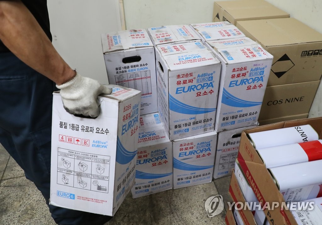 资料图片：11月7日，在首尔市一处公交车库，一名工作人员清点车用尿素库存。 韩联社