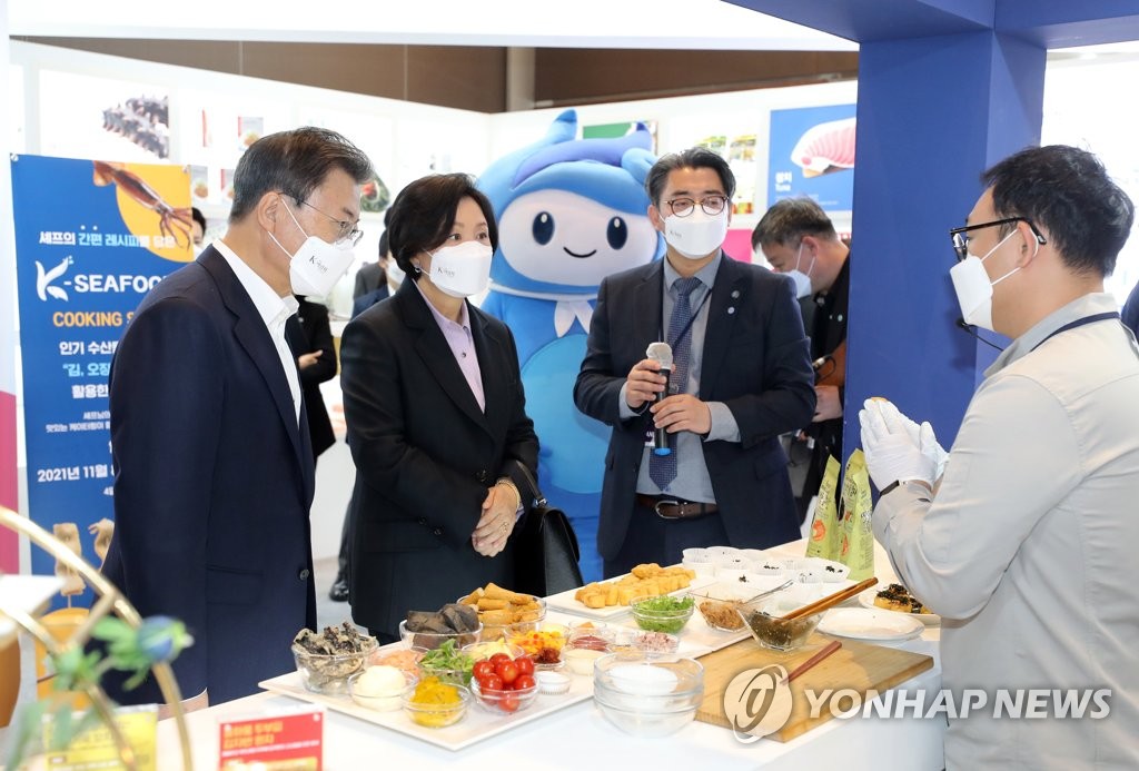 11月11日，在韩国国际会展中心（COEX），总统文在寅（左）和第一夫人金正淑参观“2021K-博览会”海洋水产部宣传馆。 韩联社