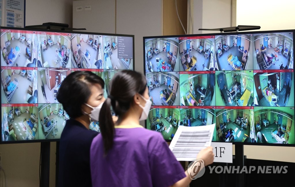 资料图片：11月15日，在首尔医疗院，医务人员查看新冠重症患者床位。 韩联社