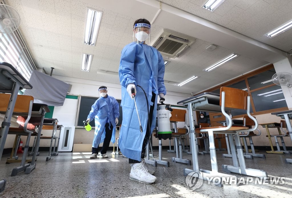 资料图片：工作人员为考点消毒。 韩联社