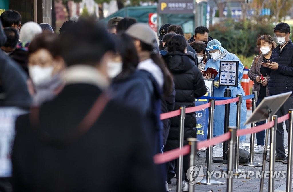 资料图片：11月17日，在设于首尔松坡区卫生站的新冠筛查站，市民排队等待接受新冠病毒检测。 韩联社