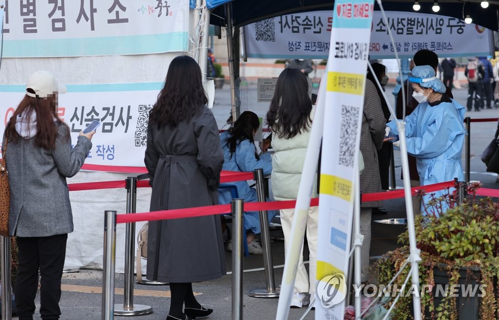 资料图片：11月17日，在设于首尔站的临时筛查诊所，市民排队等待接受新冠病毒检测。 韩联社