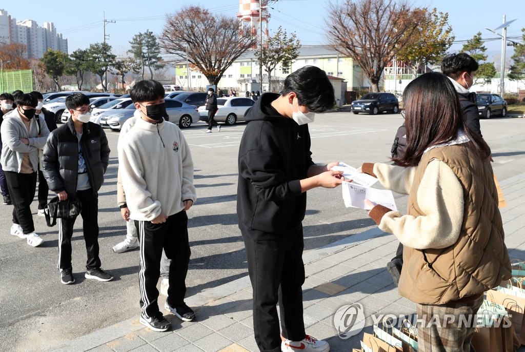 资料图片：11月17日，韩国高考进入倒计时最后一天。图为江原道春川高中的考生排队领取准考证。 韩联社