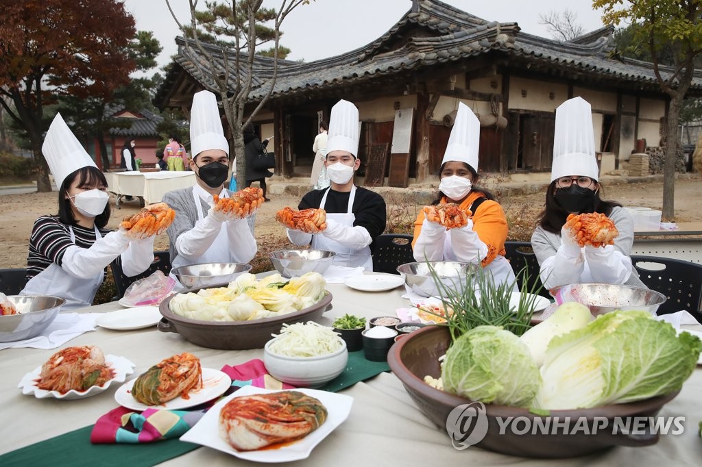 资料图片：2020年11月19日，在首尔国立民俗博物馆，外国人正在体验腌制韩国越冬泡菜。 韩联社