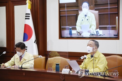 11月23日，在政府首尔大楼，经济副总理兼企划财政部长官洪楠基（右）主持召开紧急经济中央对策本部第48次会议。 韩联社