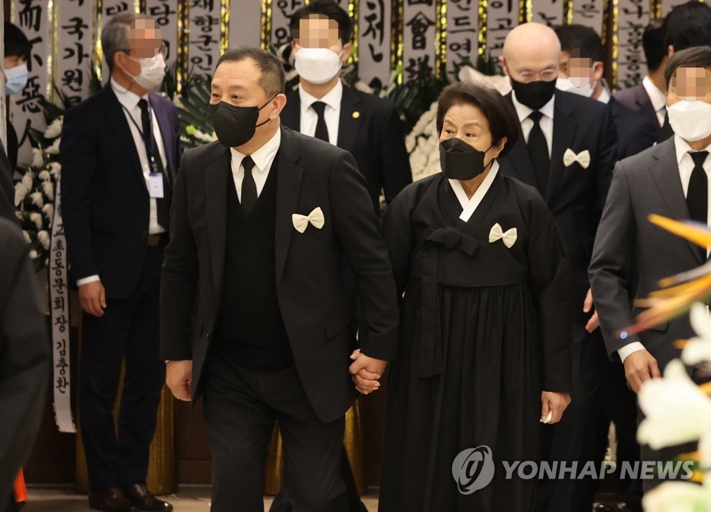 资料图片：11月25日，在首尔世福兰斯医院殡仪馆，已故前总统全斗焕的长子全宰国（左一）与李顺子在入殓仪式结束后一起回到灵堂。 韩联社