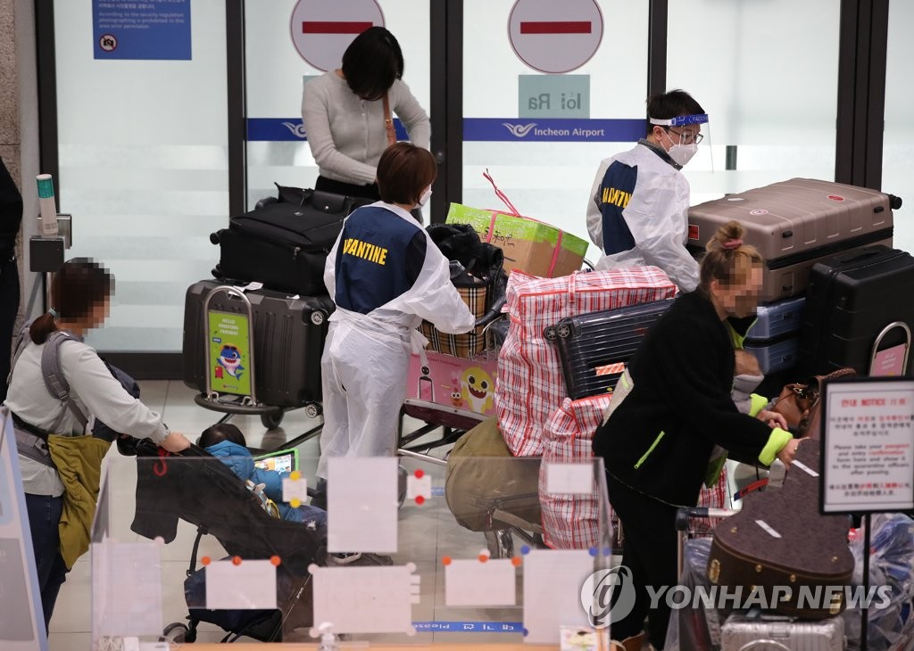 资料图片：11月28日，在仁川国际机场，防疫工作人员正在忙碌地工作。 韩联社