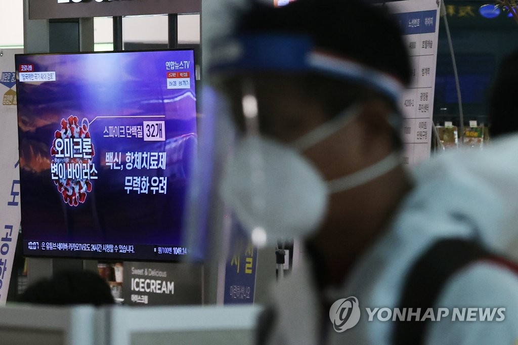 资料图片：11月29日上午，一名身穿防护服的旅客通过仁川国际机场入境。 韩联社
