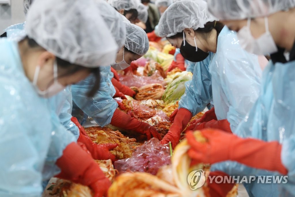 资料图片：2021年11月30日，在岭南大学庆山校区，学生们正在参加韩国泡菜腌制活动。 韩联社