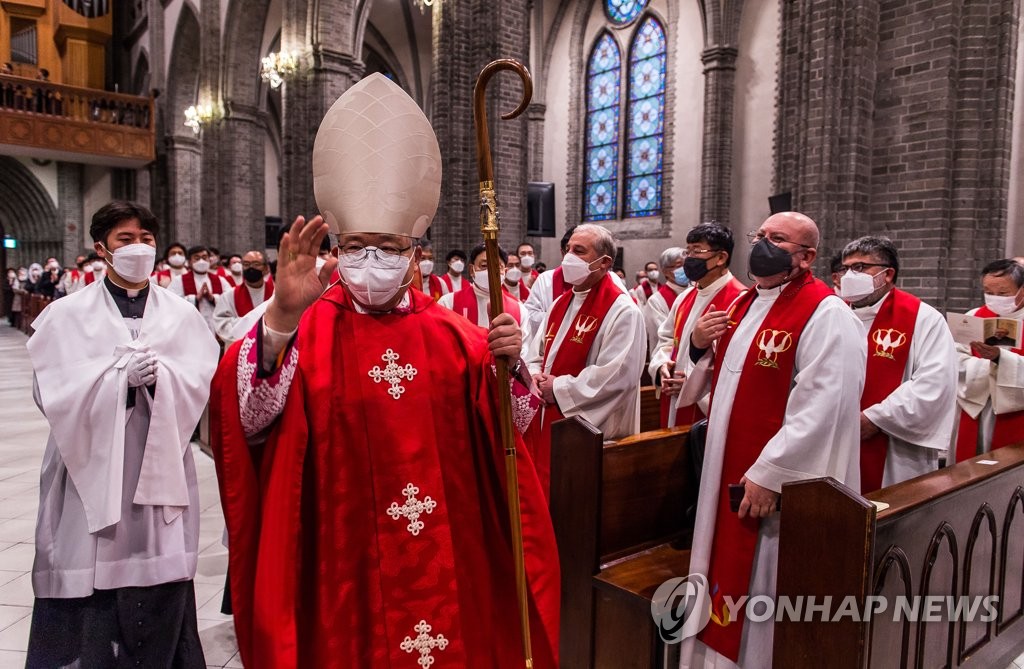 11月30日，在首尔明洞天主教堂，首尔总教区区长、枢机主教廉洙政在离任弥撒上举手致意。 韩联社/联合摄影记者团