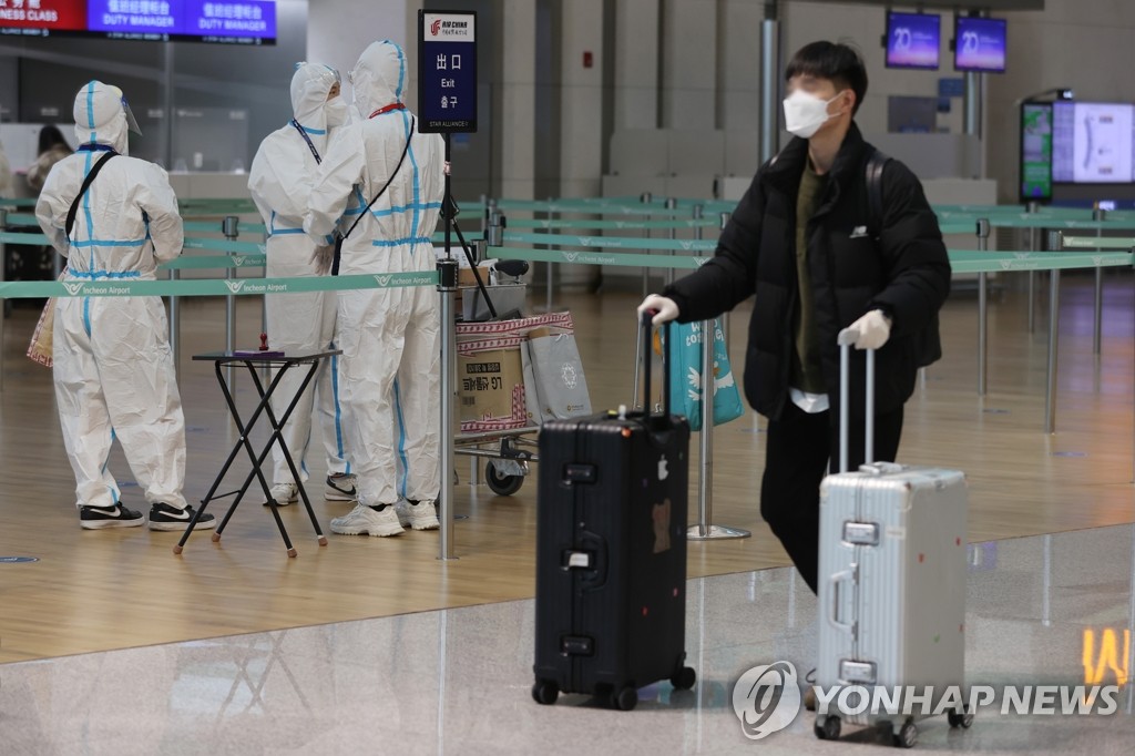 资料图片：机场防疫人员身着防护服工作。 韩联社