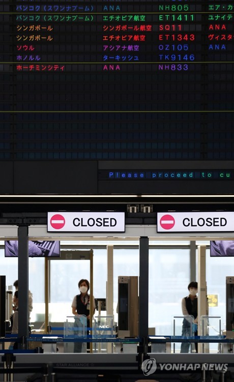 11月30日，在日本成田国际机场，安检人员戴着口罩工作。 韩联社
