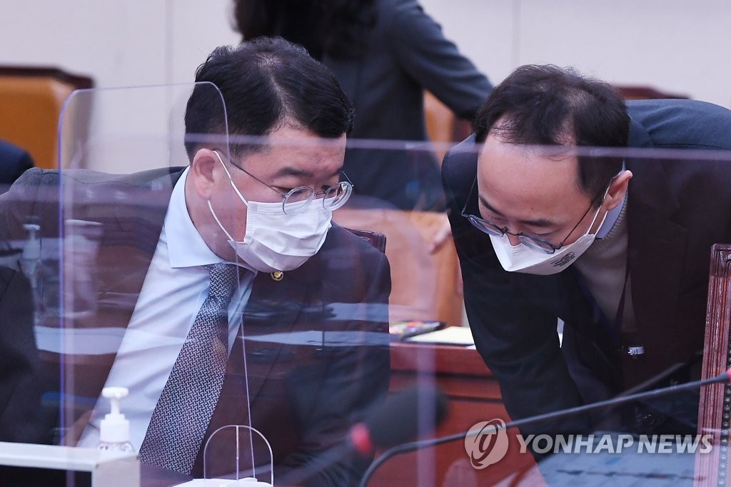 12月1日，在国会外委会全会，崔钟建（左）与下属交谈。 韩联社/国会摄影记者团供图（图片严禁转载复制）