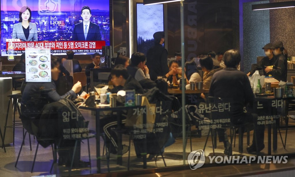 12月1日，在首尔钟路区的一家餐厅，食客们正在收看有关境内出现奥密克戎感染病例的新闻报道。 韩联社