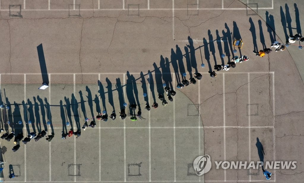 资料图片：市民排队接受新冠检测。 韩联社