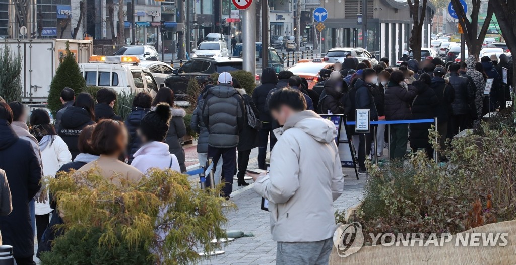资料图片：在首尔一处新冠筛查诊所，市民们排队待检。 韩联社