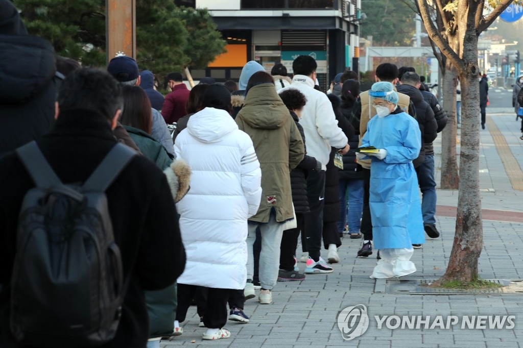 12月8日，在首尔市松坡区卫生站的新冠筛查诊所，市民们排长队等待核酸检测。 韩联社