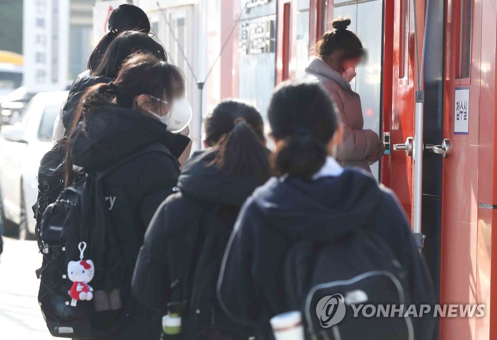 资料图片：12月8日，在庆尚南道一处筛查诊所，学生们排队等待新冠检测。 韩联社