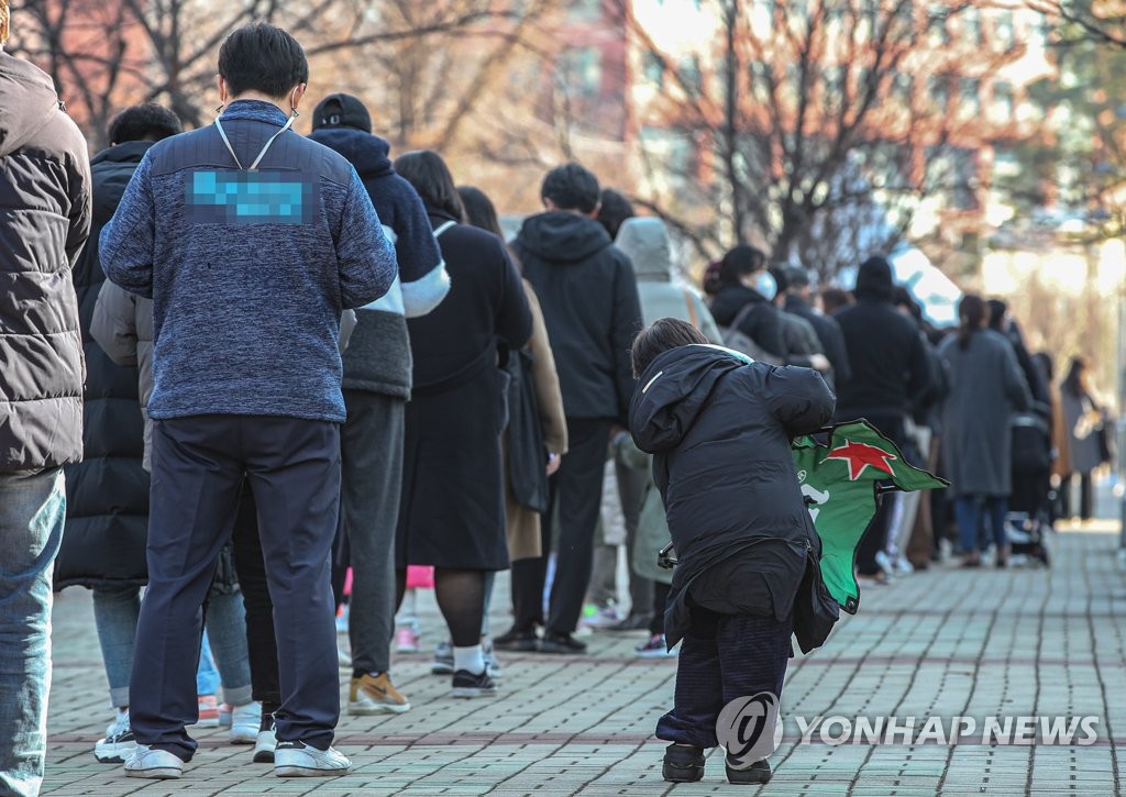 资料图片：12月8日，在首尔麻浦区的一处临时筛查诊所，市民排队待检。 韩联社