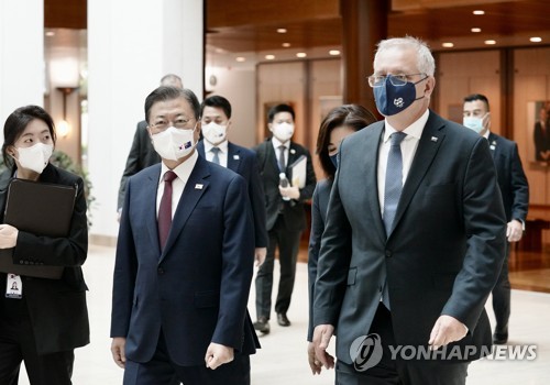 12月13日，在位于澳大利亚堪培拉的国会大厦，韩国总统文在寅（左）和澳大利亚总理斯科特·莫里森步入会场。 韩联社