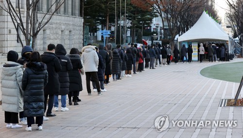 资料图片：12月13日，在设于首尔广场的筛查诊所，市民排队接受病毒检测。 韩联社