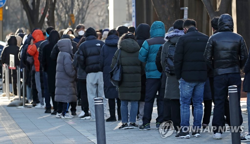 资料图片：12月13日，在首尔松坡区卫生站前的临时筛查诊所，市民们排队候检。 韩联社