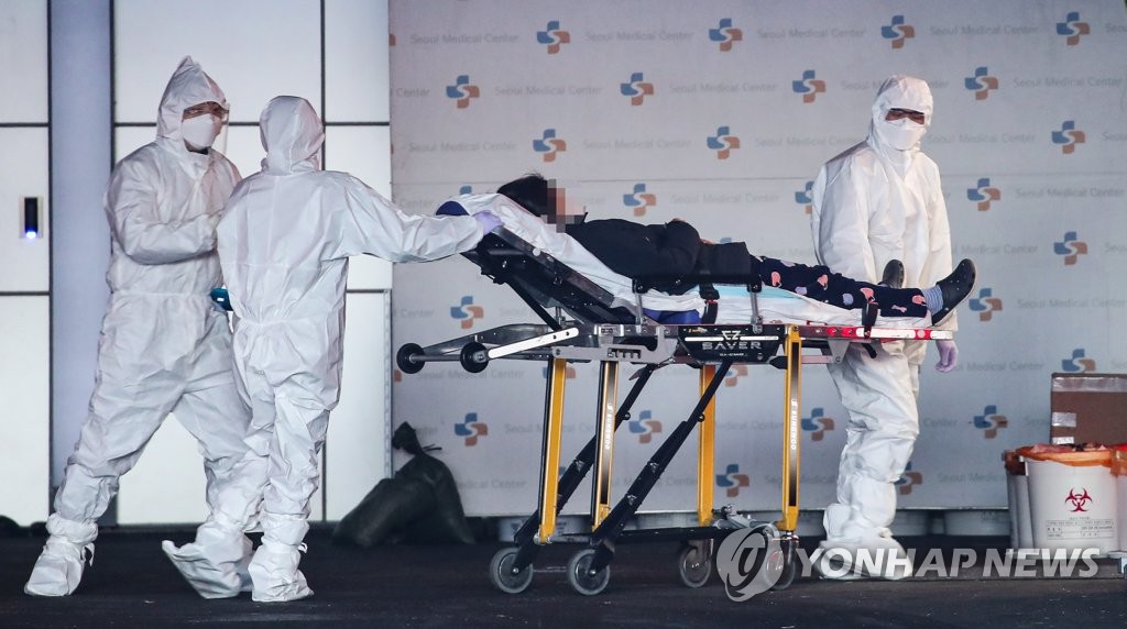 资料图片：12月19日，在首尔医疗院，医护人员正在护送危重症患者。 韩联社