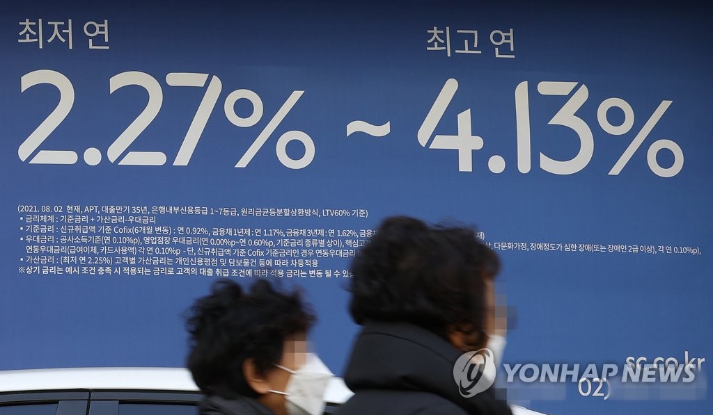 图为首尔市区一家银行挂出的有关房贷利率横幅，摄于2021年12月20日。 韩联社