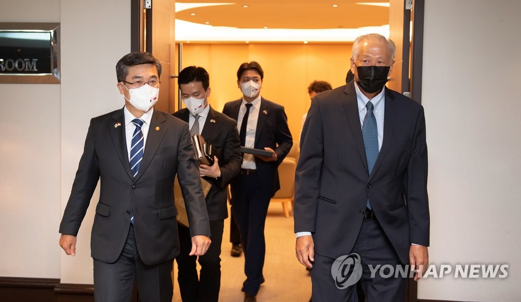 12月23日，在新加坡国防部，徐旭与黄永宏走向会场。 韩联社/韩国防部供图（图片严禁转载复制）