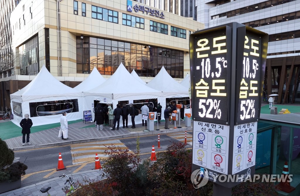 资料图片：12月27日，在首尔松坡区卫生站的新冠筛查诊所，市民们在寒风中排队做核酸检测。 韩联社