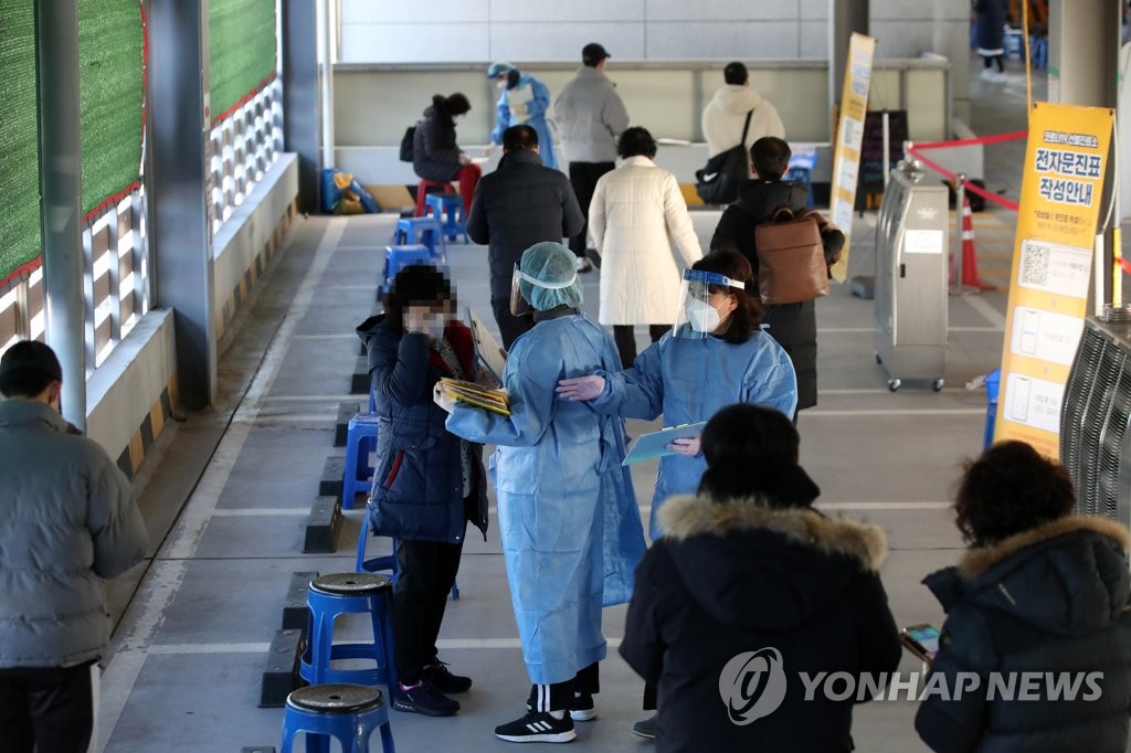 资料图片：12月27日，在光州市北区卫生站的新冠筛查诊所，市民们填写问诊表。 韩联社