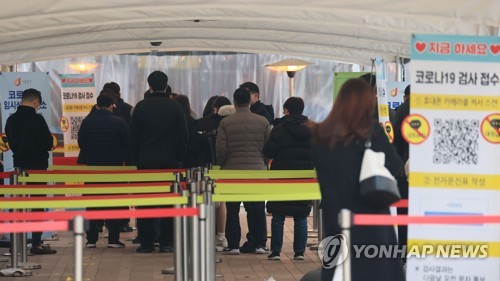 资料图片：12月29日，在设于首尔市政府办公楼的新冠临时筛查诊所，市民排队待检。 韩联社