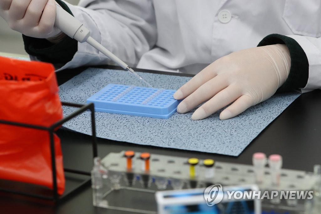 12月29日，在光州市保健环境研究院分子生物学室，一名研究员正在用核酸检测试剂排查奥密克戎。 韩联社