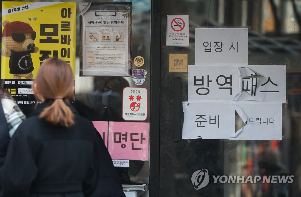 资料图片：一餐厅前贴着关于防疫通行证的通知。 韩联社