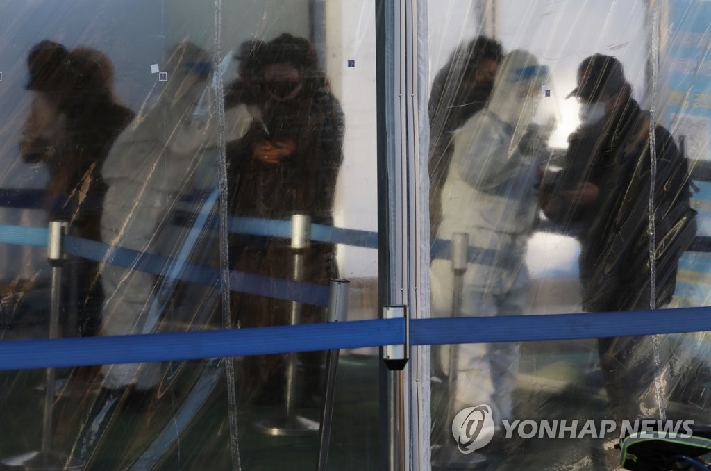 资料图片：12月31日，在首尔市东大门区的一处临时筛查诊所，市民排队等待接受核酸检测。 韩联社