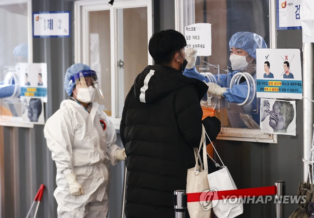 资料图片：1月2日，在设于首尔站广场的筛查诊所，一名市民接受核酸检测。 韩联社